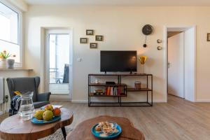 un soggiorno con televisione e tavolo di Aquamarina 17 a Heiligenhafen