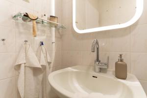 un bagno bianco con lavandino e specchio di Aquamarina 17 a Heiligenhafen Altre 24 foto