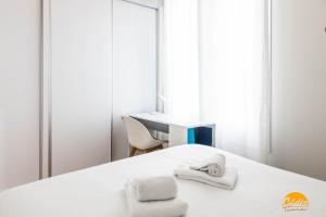 1 dormitorio con 1 cama con toallas en Nature Home by Cadiz Time, en Cádiz