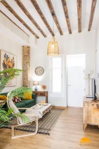 sala de estar con paredes blancas y sofá verde en Nature Home by Cadiz Time, en Cádiz