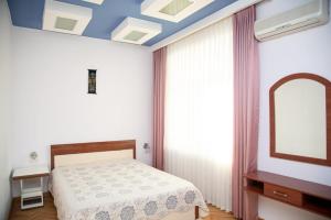 um quarto com uma cama e um espelho em SAHIL GARDEN Uzeir Gadgibekova Street em Baku