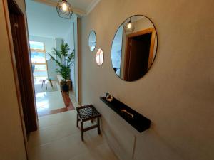 a bathroom with a mirror on the wall and a chair at Alojamientos Viveiro - Ático Playa de Covas in Viveiro