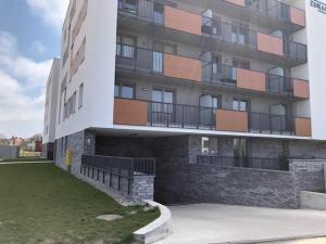 apartamentowiec z trawnikiem przed nim w obiekcie Apartament nad morzem FABIO Kołobrzeg w Kołobrzegu