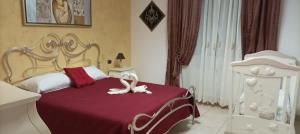 una camera con un letto e un piumone rosso e bianco di B&B CASA NISI a Villa Castelli