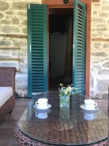 Una mesa con dos tazas y un jarrón con flores. en Lovely house in the heart of nature, en Serik