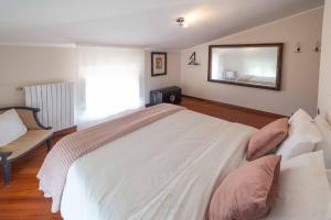a bedroom with a large white bed and a mirror at Villa Riva Lago - Apartment with garden and parking in Tavernola Bergamasca