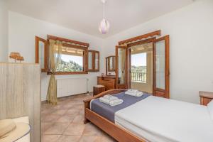 a bedroom with a bed and a large window at VILLA KONSTANTINA Sidari in (( Sgoúrna ))