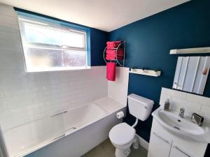 uma casa de banho com uma banheira, um WC e um lavatório. em Beautiful & Vibrant City Centre House em Canterbury