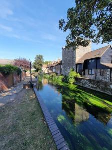 a river in front of a building next to a building at Beautiful & Vibrant City Centre House in Canterbury