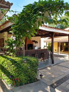 a patio of a house with a tree and flowers at Pousada Realeza Atibaia in Atibaia