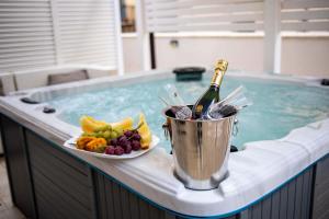 a bucket with a bottle of champagne and a plate of fruit in a tub at Abside Suite & Spa in Palermo