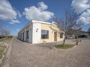 um pequeno edifício branco com uma árvore em frente em Masseria Chinunno em Altamura