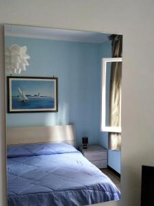 a blue bedroom with a bed and a window at A due passi dal mare in Sori
