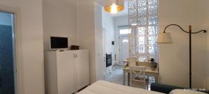 sala de estar blanca con mesa y TV en Casa del Mare Appartamento Bucceri Salvatore, en Letojanni