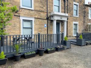 a fence with potted plants in front of a building at The Roxburgh Guest Accommodation in Berwick-Upon-Tweed