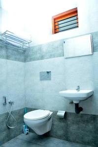 een badkamer met een toilet en een wastafel bij Saaketh Holiday Home in Kozhikode