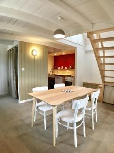 - une cuisine avec une table en bois et des chaises blanches dans l'établissement Dernier Ecolodge avant NewYork, à Plogoff