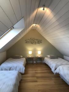 a attic room with two beds and two lamps at Dernier Ecolodge avant NewYork in Plogoff