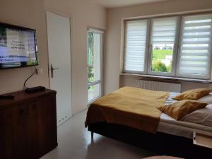 a bedroom with a bed and a flat screen tv at Homestay Willa Anna in Karpacz