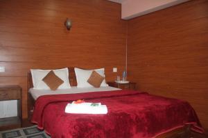 a bedroom with a large bed with a red blanket at Happy Valley Homestay in Darjeeling