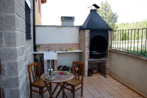 a patio with a table and chairs and a fireplace at Rosella de Rubielos in Fuentes de Rubielos