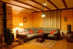 a living room with a couch and a tv at Rosella de Rubielos in Fuentes de Rubielos