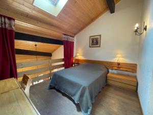 a bedroom with a bed in a room with wooden ceilings at CRYSTAL 25 - Duplex centre village et proche pistes, vue montagnes - Garage in La Clusaz