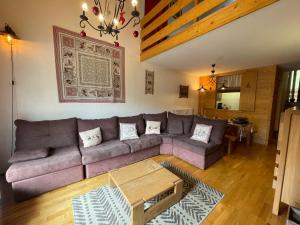 a living room with a couch and a table at CRYSTAL 25 - Duplex centre village et proche pistes, vue montagnes - Garage in La Clusaz