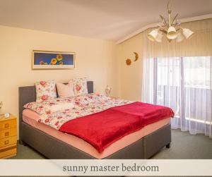um quarto com uma cama grande e um cobertor vermelho em Apartment Valerie - Villa Mühlei Alterbachstr 9 em Anif