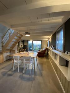 une salle à manger avec une table, des chaises et un escalier dans l'établissement Dernier Ecolodge avant NewYork, à Plogoff