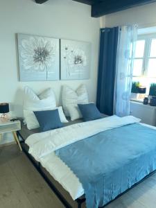 a bedroom with a large bed with blue and white pillows at Apartment threeRivers in Passau