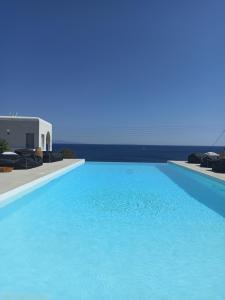 a large blue swimming pool next to a white building at Aloe Mare Suites in Liaropá