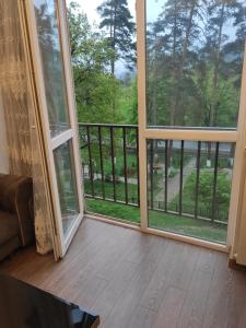 a screened in porch with a view of the woods at Apartment Likani in Borjomi