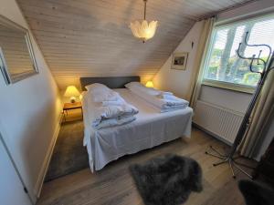 En eller flere senge i et værelse på Kollund Cottage