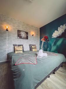 een slaapkamer met een groen bed met een vogel aan de muur bij Retour vers le futur By Carl-Emilie 4 pers in Épinal