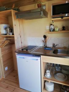 een kleine keuken met een wastafel en een koelkast bij La Roulotte du Herdal in Profondeville