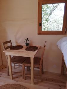 un tavolo e due sedie in una stanza con finestra di La Roulotte du Herdal a Profondeville