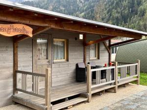 une petite maison avec une terrasse couverte et une terrasse dans l'établissement Bungalow Li Presi in Camping Cavresc, Via dal Cavresc 1, 7746 Le Prese-Poschiavo, à Poschiavo