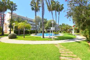 un parque con piscina y palmeras en Apartamento Jardines del Saladar Javea - 5038, en Jávea