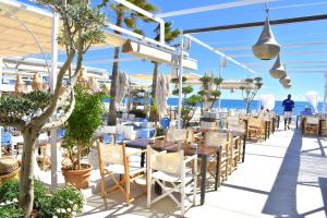un restaurante en la playa con mesas y sillas en Apartamento Jardines del Saladar Javea - 5038, en Jávea
