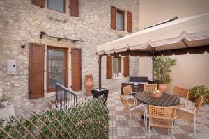 a patio with a table and chairs and an umbrella at Casa Delle Stelle in Torri del Benaco