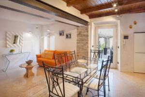 阿尔比萨诺Casa Delle Stelle的带玻璃桌椅的客厅 更多13张照片