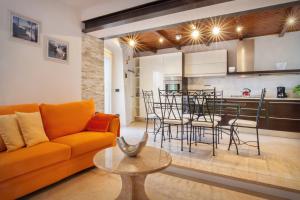 een woonkamer met een oranje bank en een keuken bij Casa Delle Stelle in Torri del Benaco