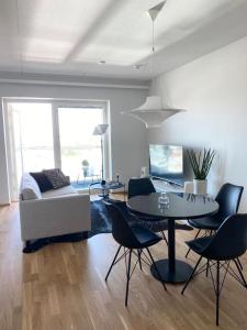 een woonkamer met een tafel en stoelen en een bank bij Upea 12 kerroksen kaksio ydinkeskustassa in Oulu