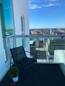 a chair on a balcony with a view of a city at Upea 12 kerroksen kaksio ydinkeskustassa in Oulu