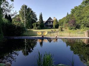 a house with a pond in front of a house at Stilbjerg Sleep&Hygge in Varde