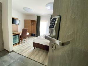 una camera d'albergo con una porta con un letto e una camera da letto di City Rooms Gede a Lipsia