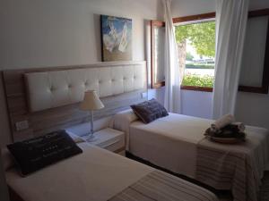 a hotel room with two beds and a window at Apt playa de Muro ca n Ines - 1ª linea de playa in Port d'Alcudia