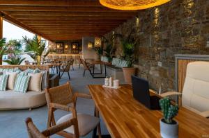 a restaurant with chairs and tables and a brick wall at Le Palme Mykonos in Klouvas