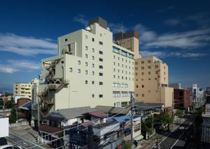 a large white building in the middle of a city at Hotel Grand View Takasaki in Takasaki